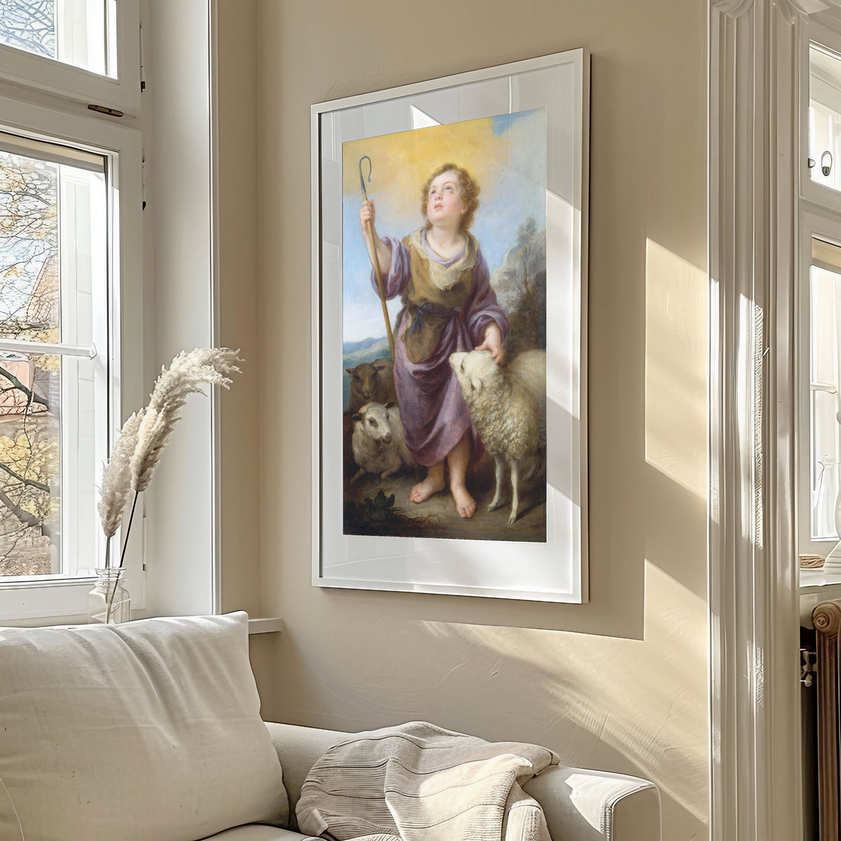 Framed art print of The Good Shepherd by Bartolomé Esteban Murillo, in a sunlit living room above a sofa