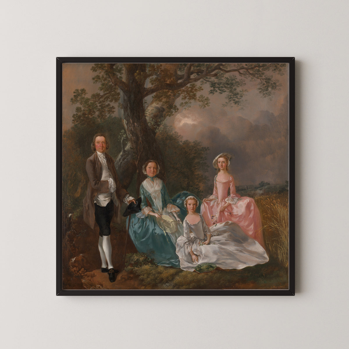 Framed art print of The Gravenor Family by Thomas Gainsborough, in a black frame on a pale wall