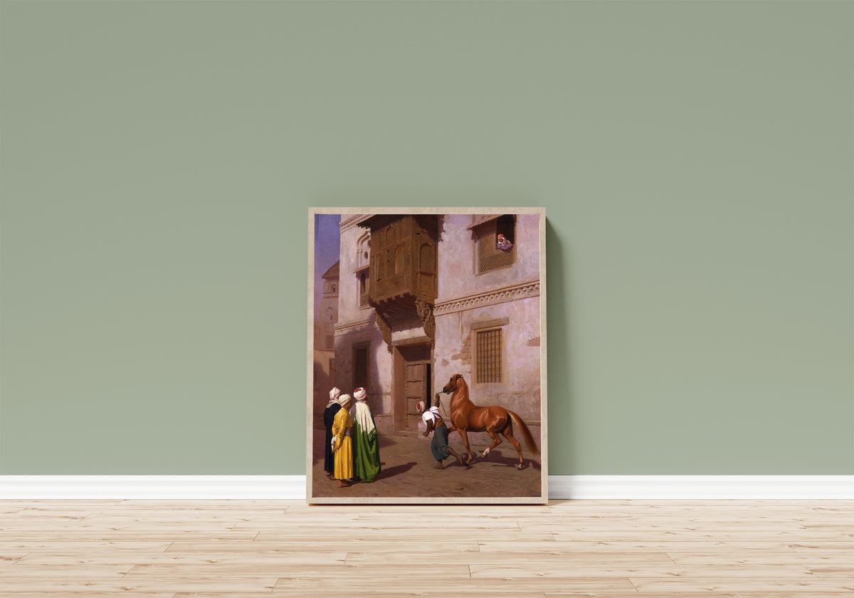 Framed art print of The Horse Market by Jean-Léon Gérôme, in a light wood frame leaning on a sage green wall above a wooden floor