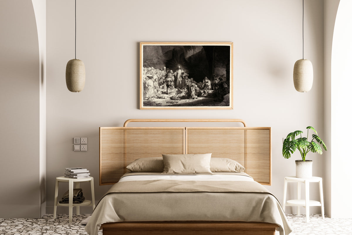 Framed art print of The Hundred Guilder Print by Rembrandt van Rijn, above a cane-headboard bed