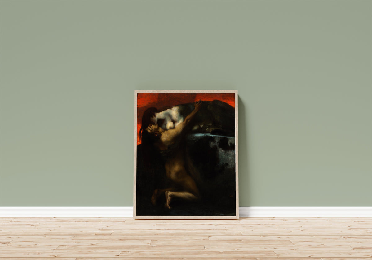 Framed art print of The Kiss of the Sphinx by Franz von Stuck, in a light wood frame leaning on a sage green wall above a wooden floor