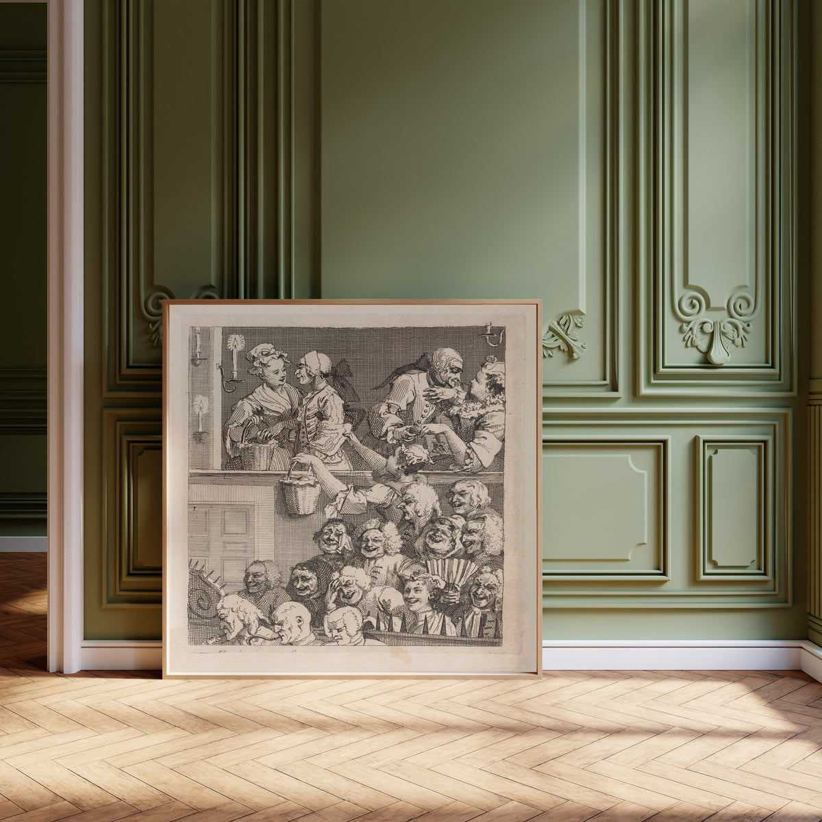 Framed art print of The Laughing Audience by William Hogarth, leaning against olive-green panelling on a herringbone floor