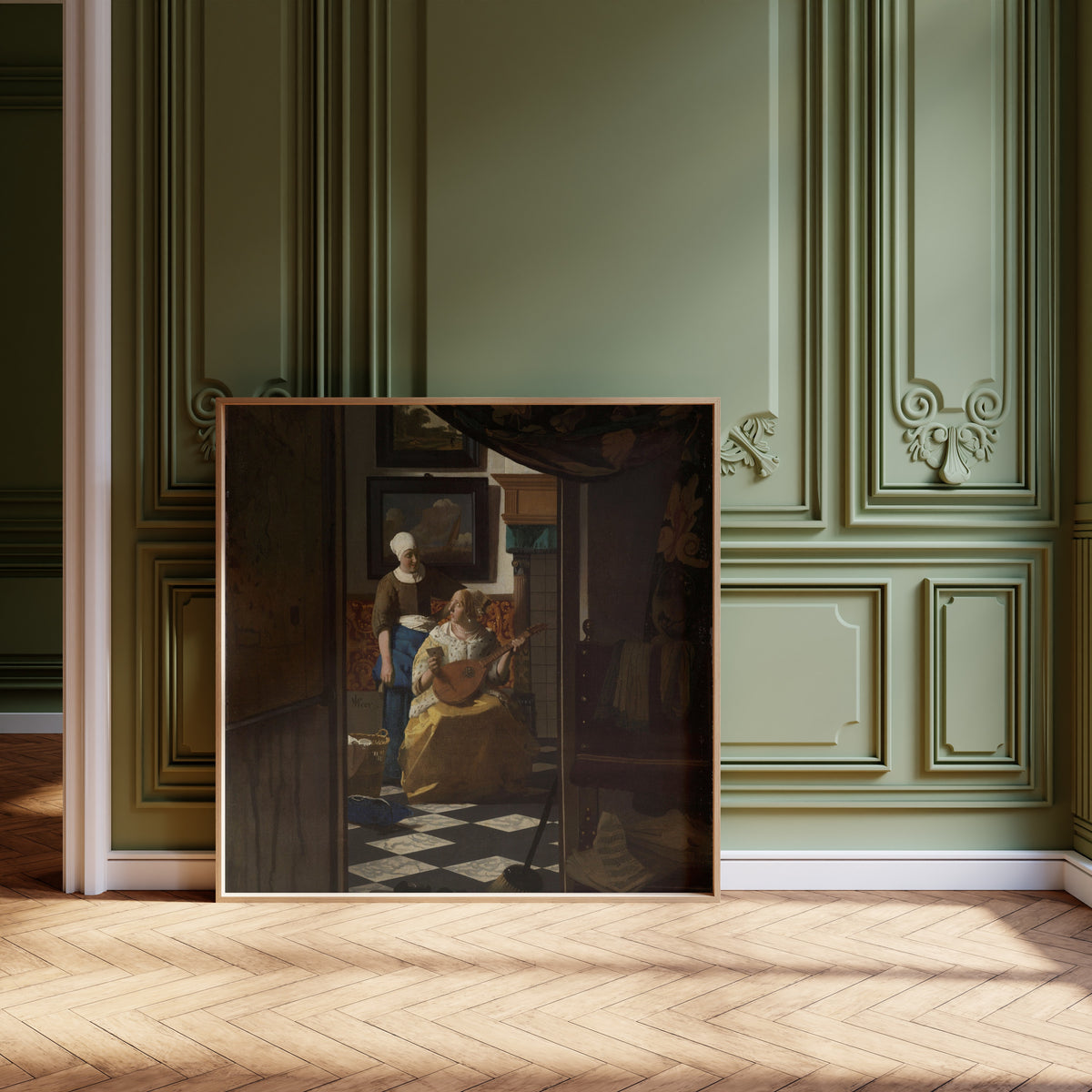 Framed art print of The Love Letter by Johannes Vermeer, leaning against olive-green panelling on a herringbone floor