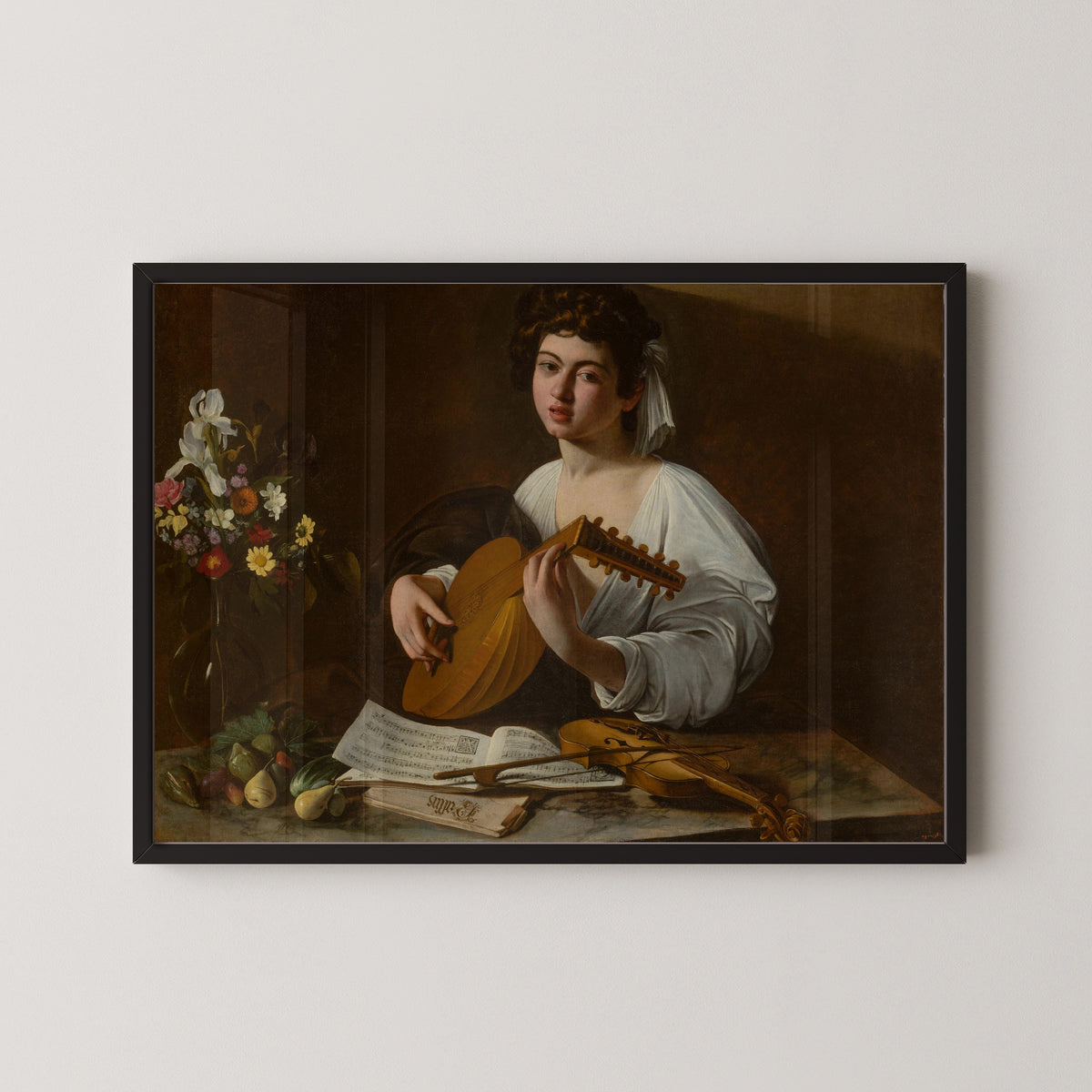 Framed art print of The Lute Player by Caravaggio, in a black frame on a pale wall