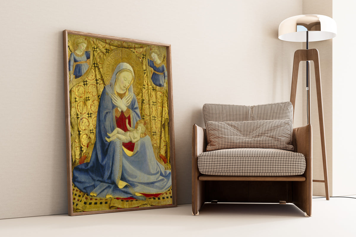Framed art print of The Madonna of Humility by Fra Angelico, leaning against a wall beside an armchair and a floor lamp