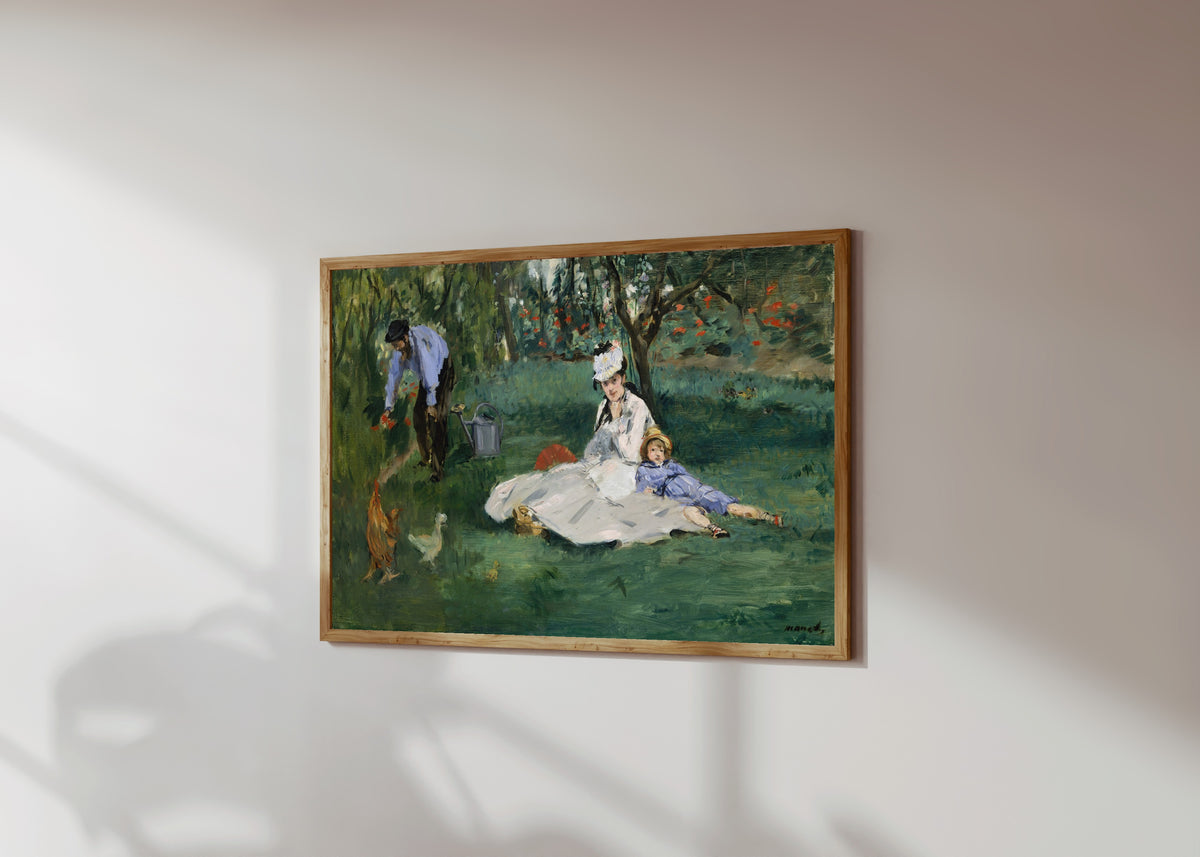 Framed art print of The Monet Family in Their Garden at Argenteuil by Édouard Manet, in a light wood frame on a sunlit white wall, seen at a slight angle