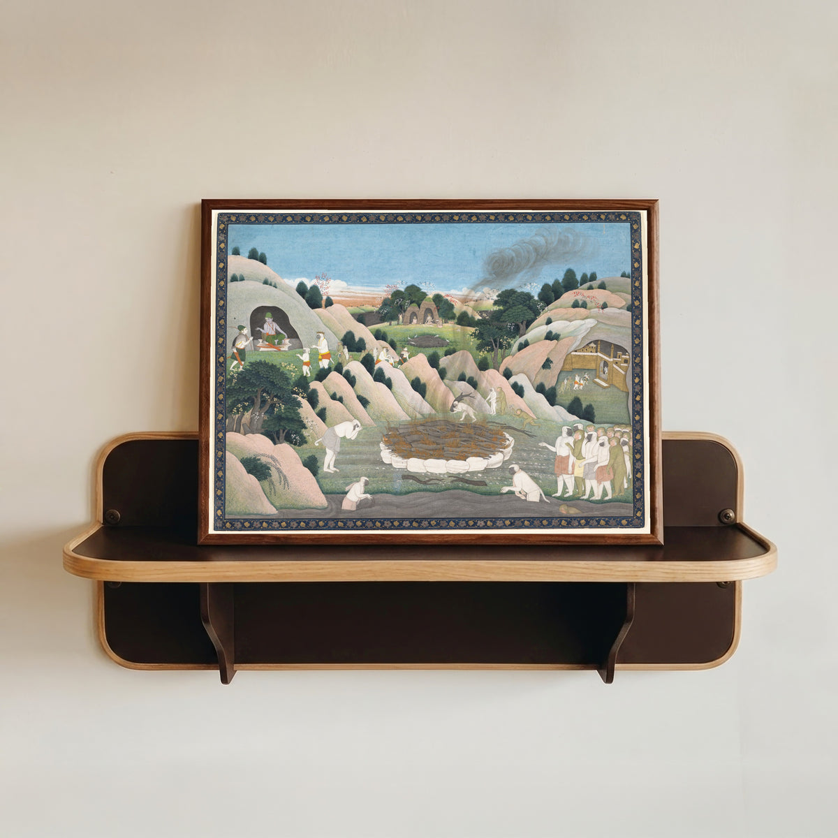 Framed art print of The Monkey King Vali's Funeral Pyre by Kangra school, in a dark wood frame resting on a wall shelf