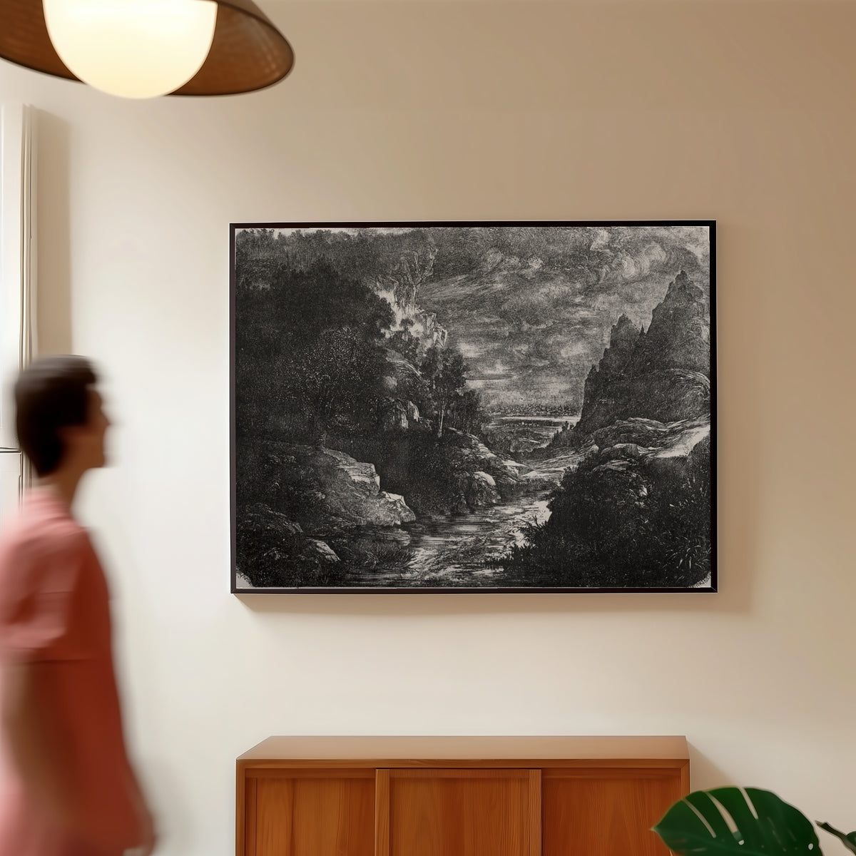 Framed art print of The Mountain Stream by Rodolphe Bresdin, in a slim black frame on a warm wall in a sunlit room