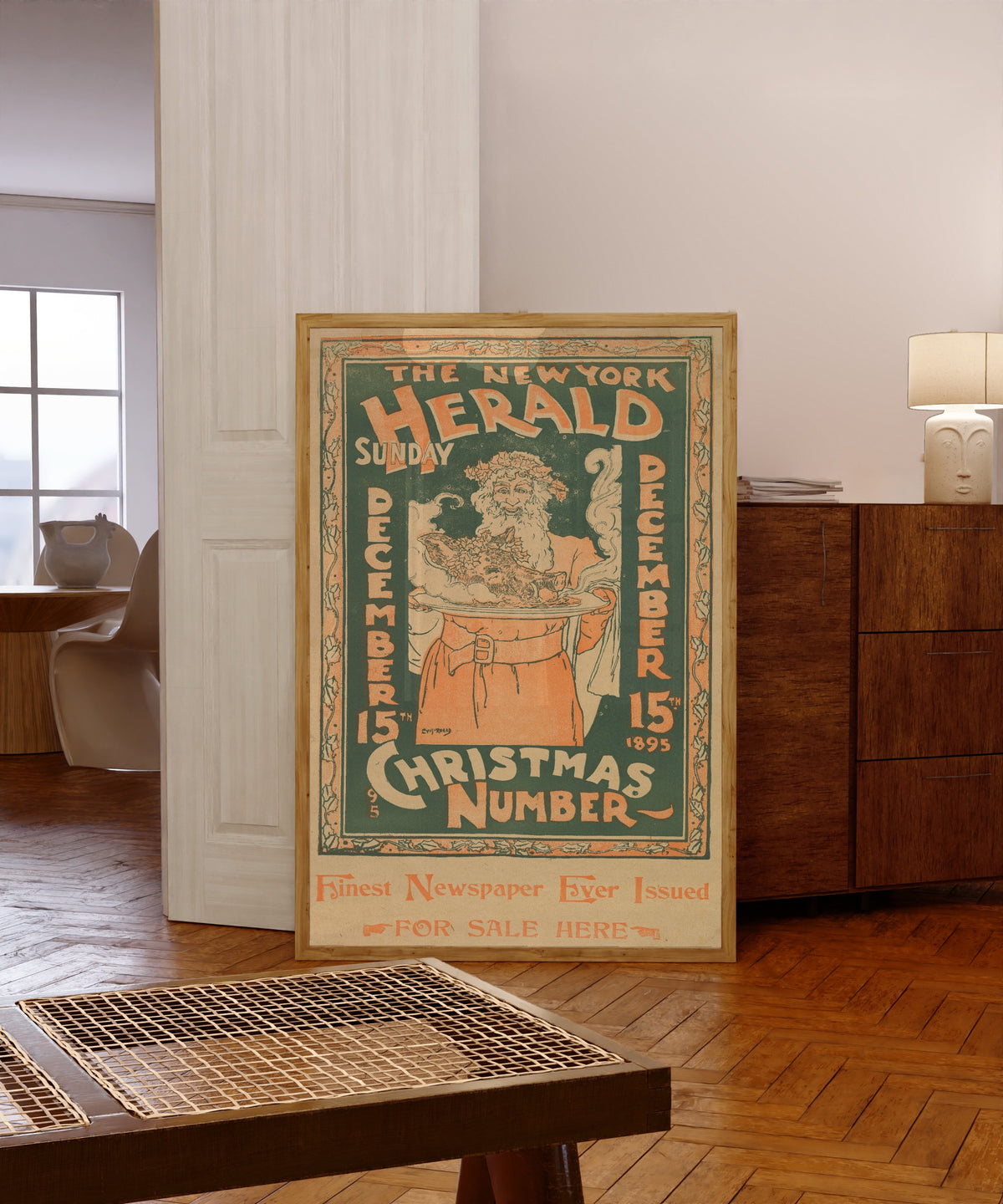 Framed art print of The New York Herald, Sunday, December 15 by Louis Rhead, in a light wood frame leaning in a warm room with a parquet floor