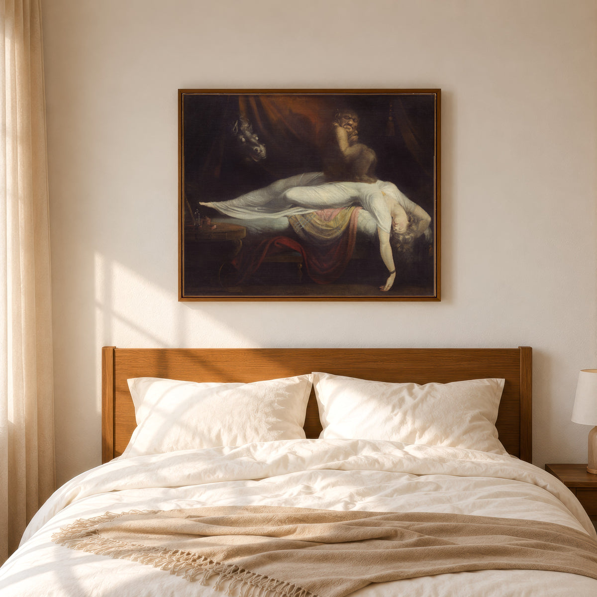 Framed art print of The Nightmare by Henry Fuseli, in a slim wood frame above a bed in a sunlit bedroom