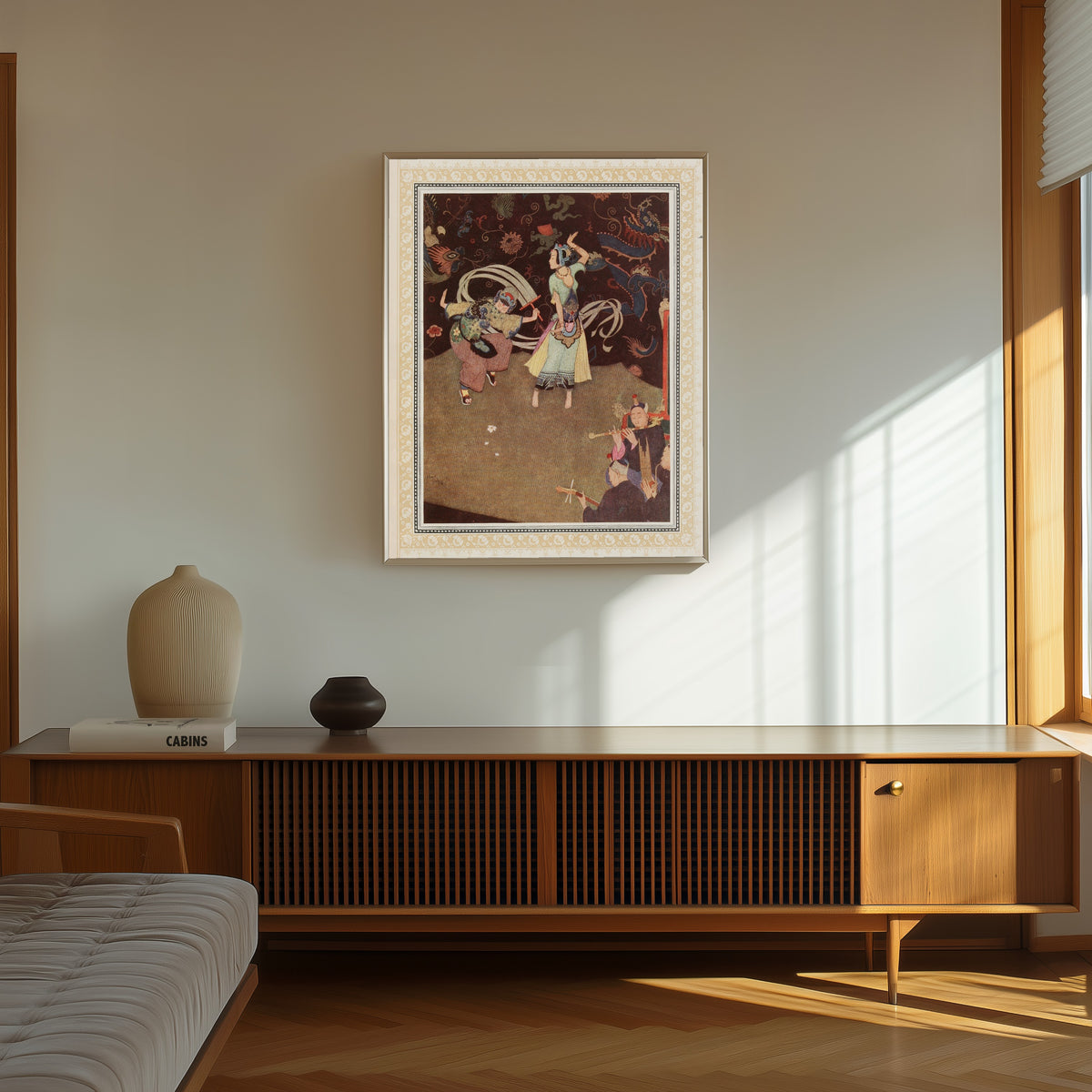 Framed art print of The Nuptial Dance of Aladdin and the Lady Bedr-el-Budur by Edmund Dulac, in a thin light frame on a sunlit wall above a wooden sideboard