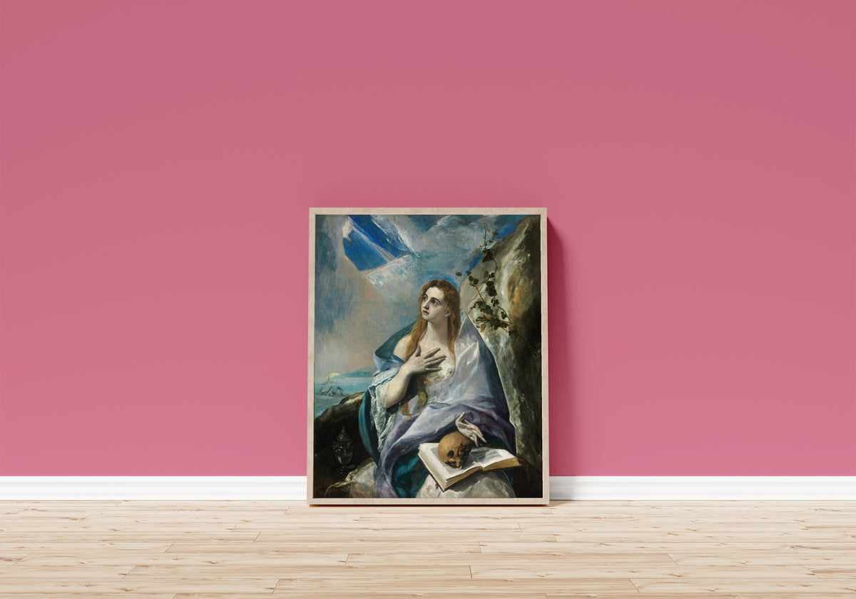 Framed art print of The Penitent Magdalene by El Greco, in a light wood frame leaning on a pink wall above a wooden floor