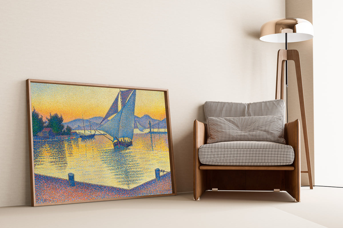 Framed art print of The Port at Sunset, Opus 236, Saint-Tropez by Paul Signac, leaning against a wall beside an armchair and a floor lamp