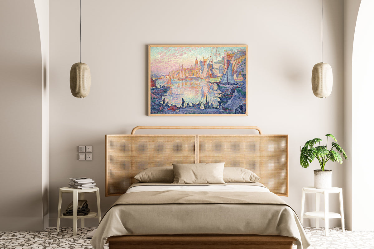 Framed art print of The Port of Saint-Tropez by Paul Signac, above a cane-headboard bed