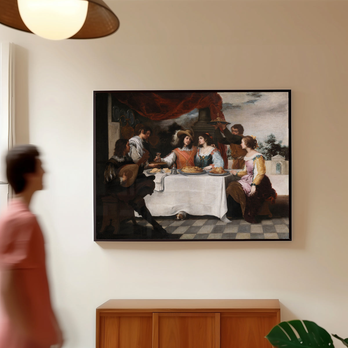 Framed art print of The Prodigal Son Feasting by Bartolomé Esteban Murillo, in a slim black frame on a warm wall in a sunlit room