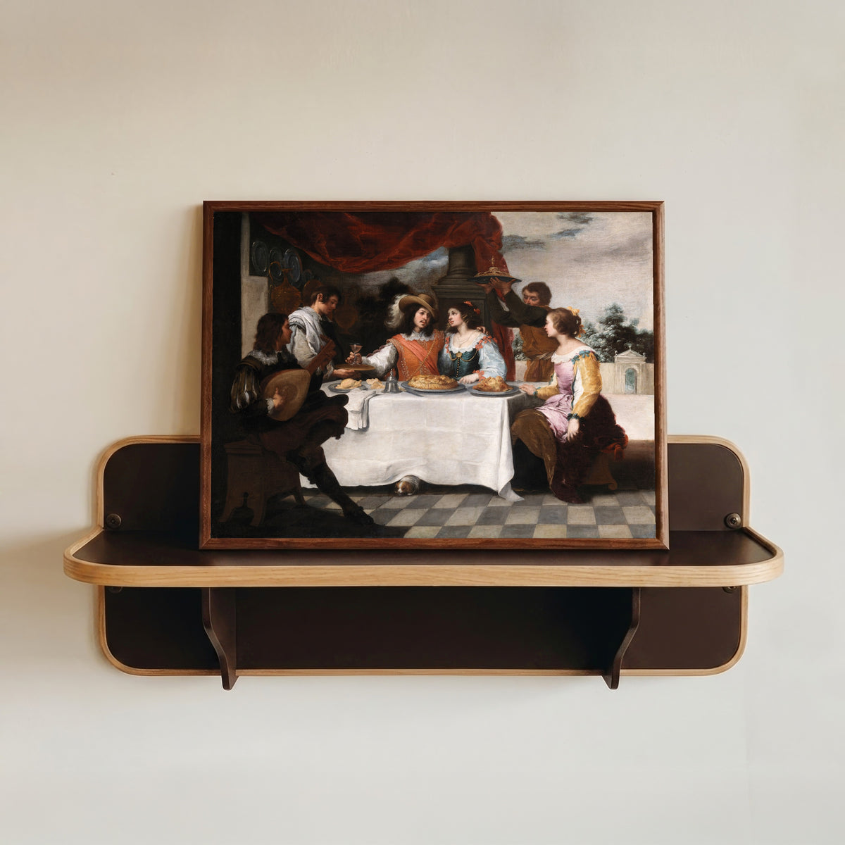 Framed art print of The Prodigal Son Feasting by Bartolomé Esteban Murillo, in a dark wood frame resting on a wall shelf