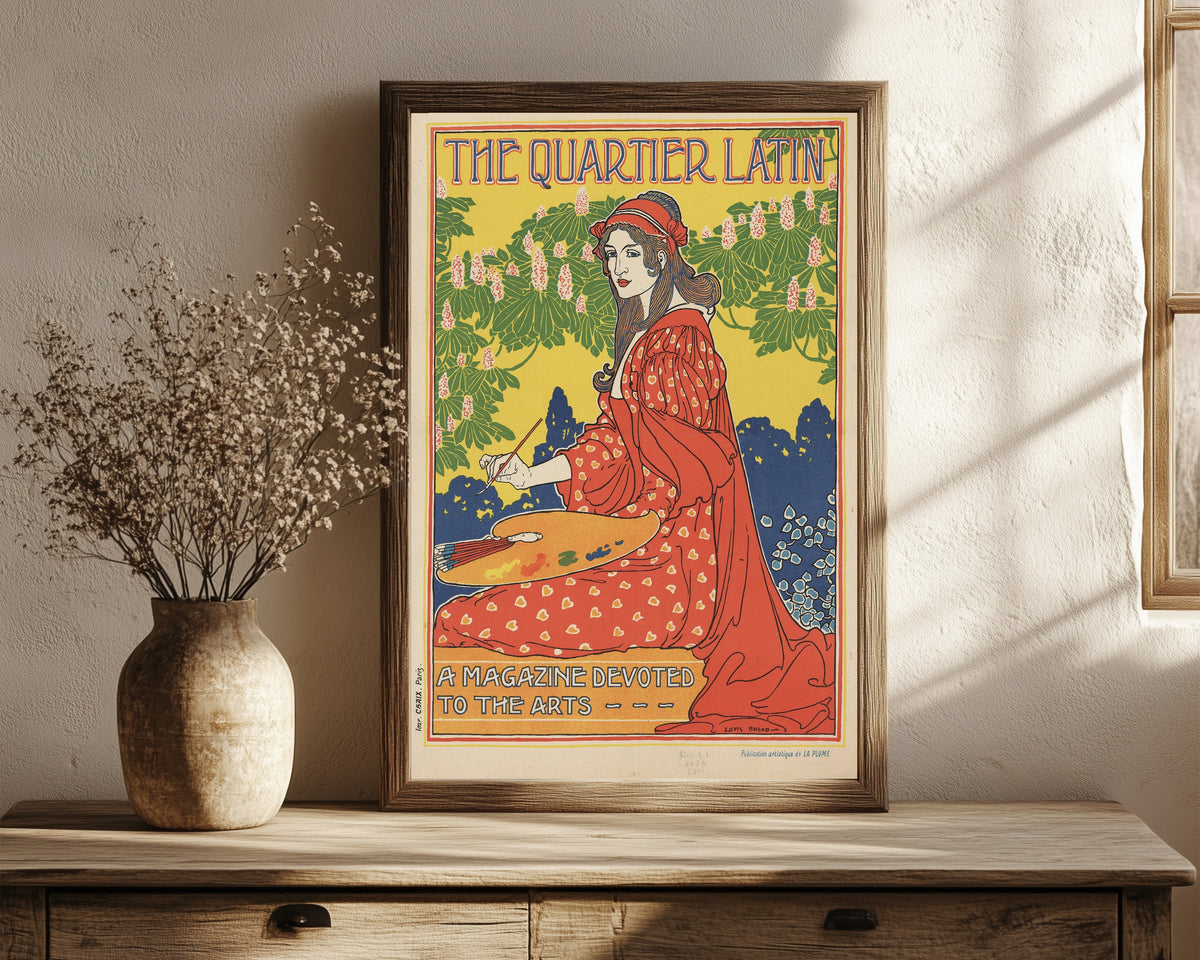Framed art print of The Quartier Latin, A Magazine Devoted to the Arts by Louis Rhead, in a dark wood frame leaning on a rustic console beside dried flowers