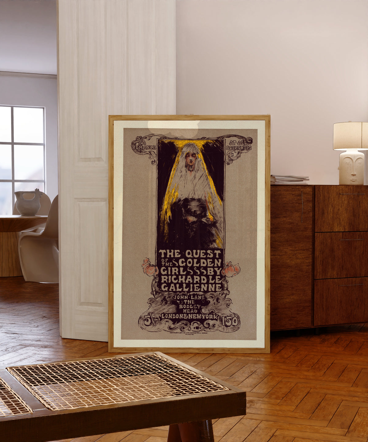 Framed art print of The Quest of the Golden Girl by Richard Le Gallienne by Ethel Reed, in a light wood frame leaning in a warm room with a parquet floor