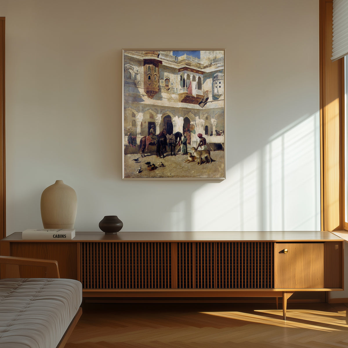 Framed art print of The Rajah Starting on a Hunt by Edwin Lord Weeks, in a thin light frame on a sunlit wall above a wooden sideboard