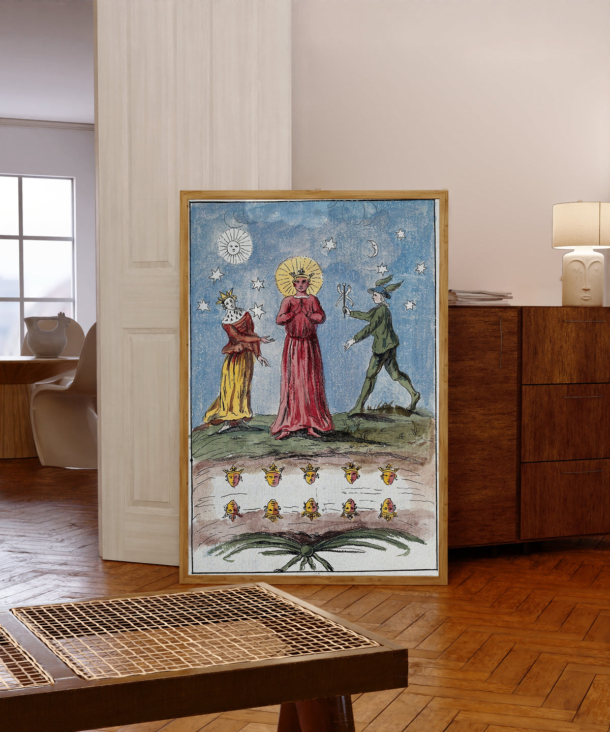 Framed art print of The Red King, the Queen and Mercury by After Nicolas Flamel, in a light wood frame leaning in a warm room with a parquet floor