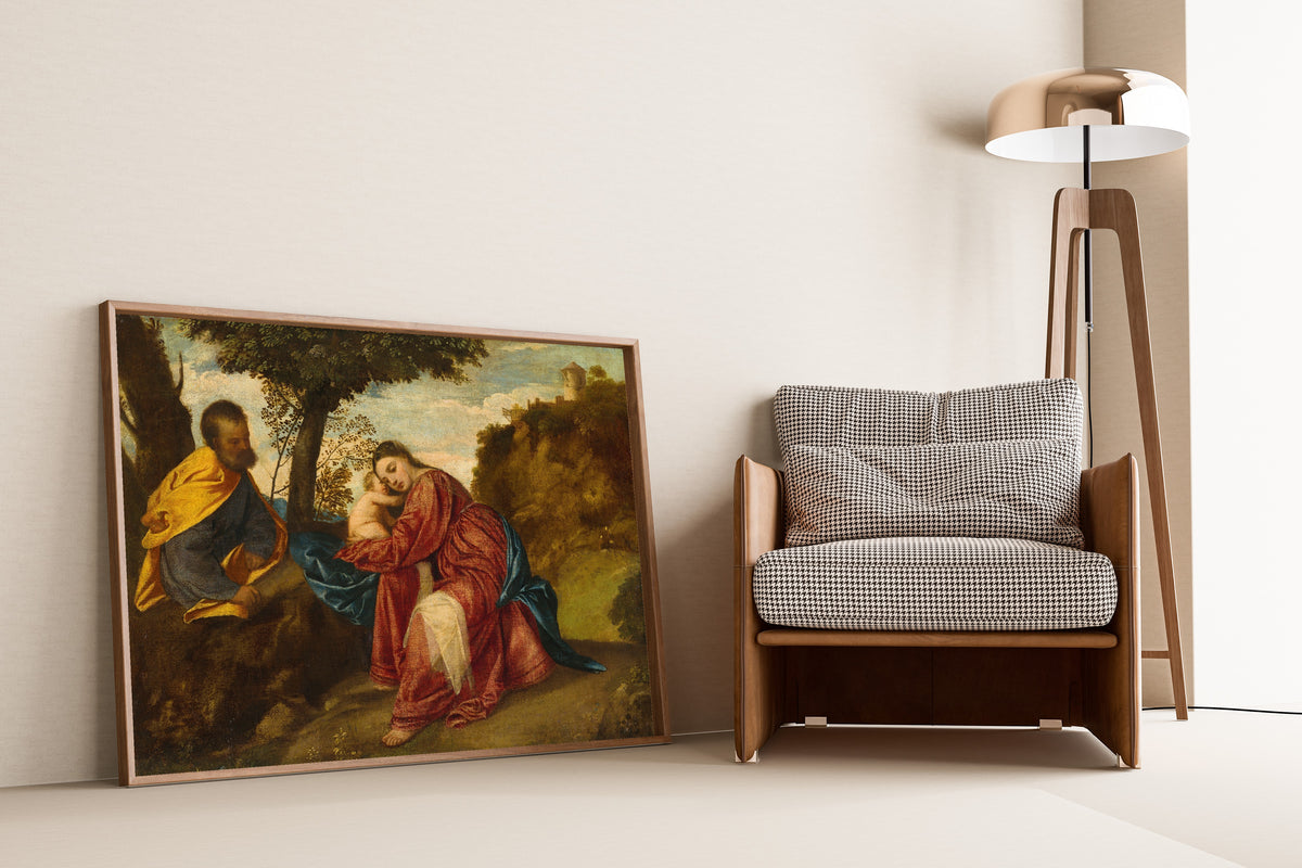 Framed art print of The Rest on the Flight into Egypt by Titian, leaning against a wall beside an armchair and a floor lamp
