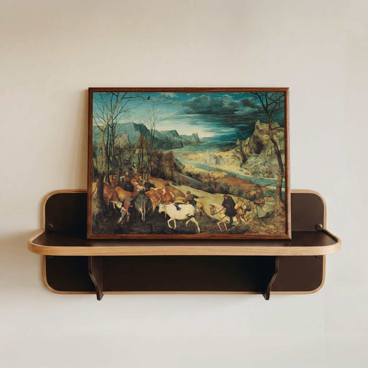 Framed art print of The Return of the Herd (Autumn) by Pieter Bruegel the Elder, in a dark wood frame resting on a wall shelf