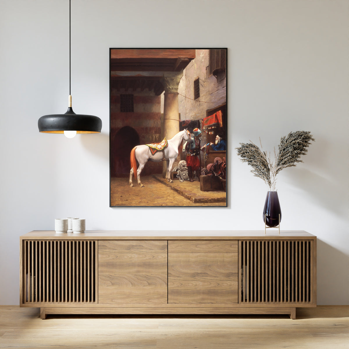 Framed art print of The Saddle Bazaar, Cairo by Jean-Léon Gérôme, above a slatted wood sideboard