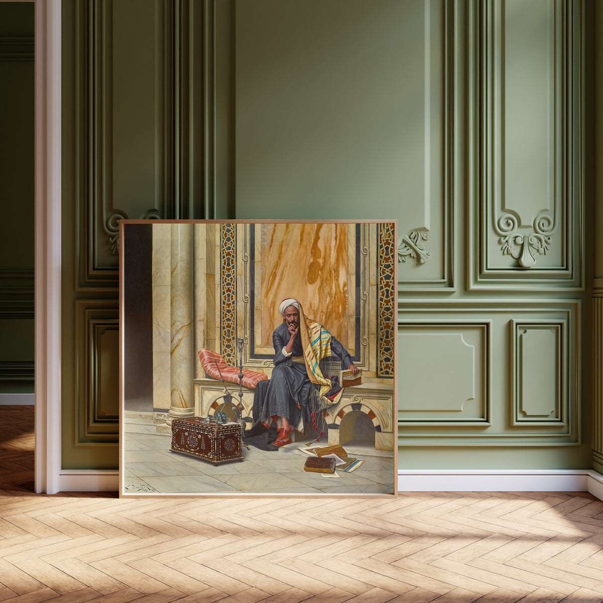 Framed art print of The Scribe by Ludwig Deutsch, leaning against olive-green panelling on a herringbone floor