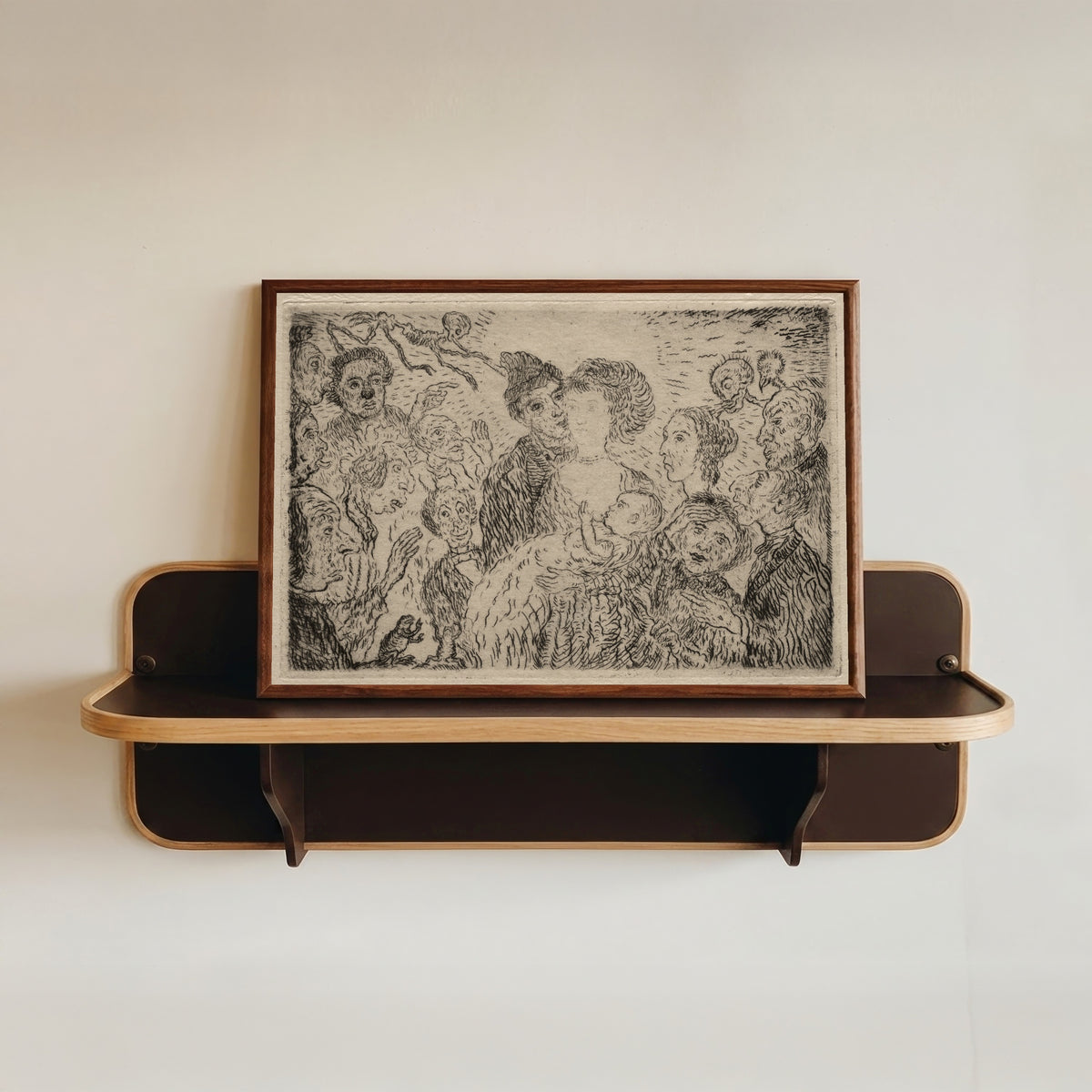 Framed art print of The Seven Deadly Sins: Envy by James Ensor, in a dark wood frame resting on a wall shelf