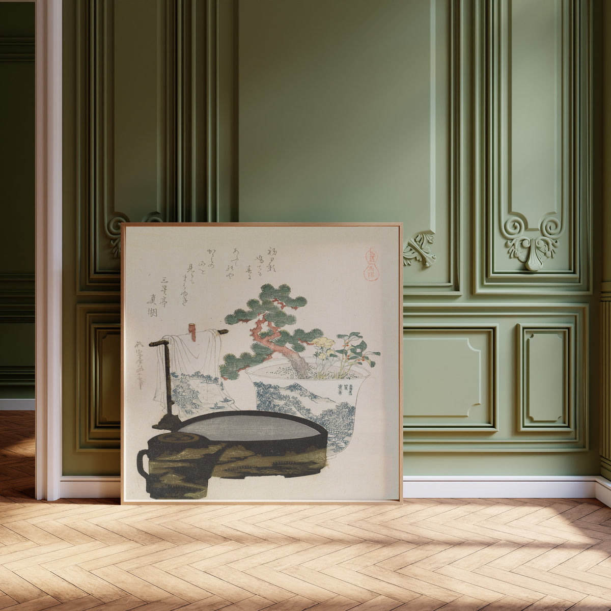 Framed art print of The Talisman by Katsushika Hokusai, leaning against olive-green panelling on a herringbone floor