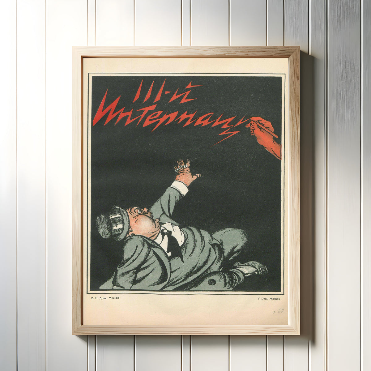 Framed art print of The Third International by Viktor Deni, in a light wood frame on a white panelled wall