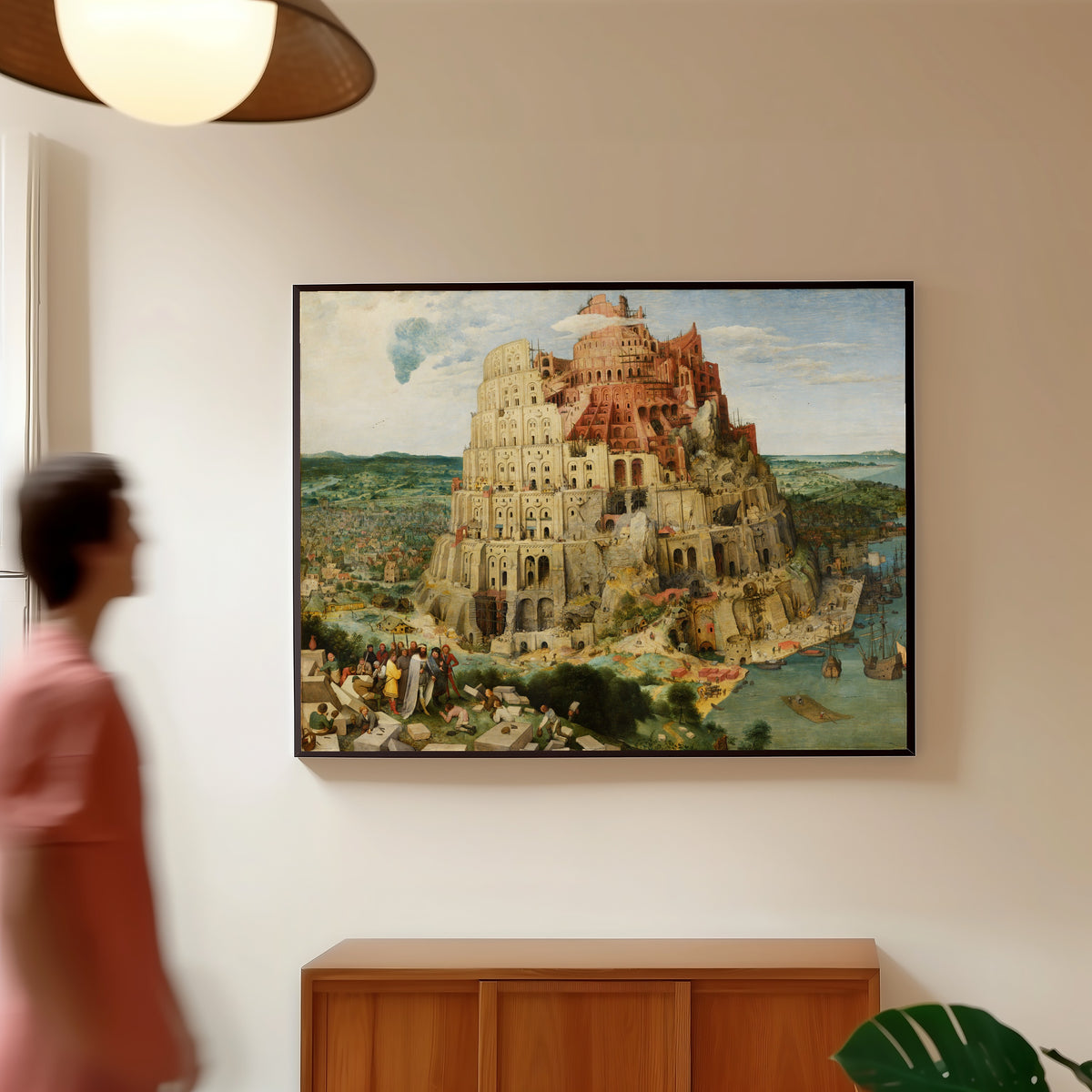 Framed art print of The Tower of Babel (Vienna) by Pieter Bruegel the Elder, in a slim black frame on a warm wall in a sunlit room