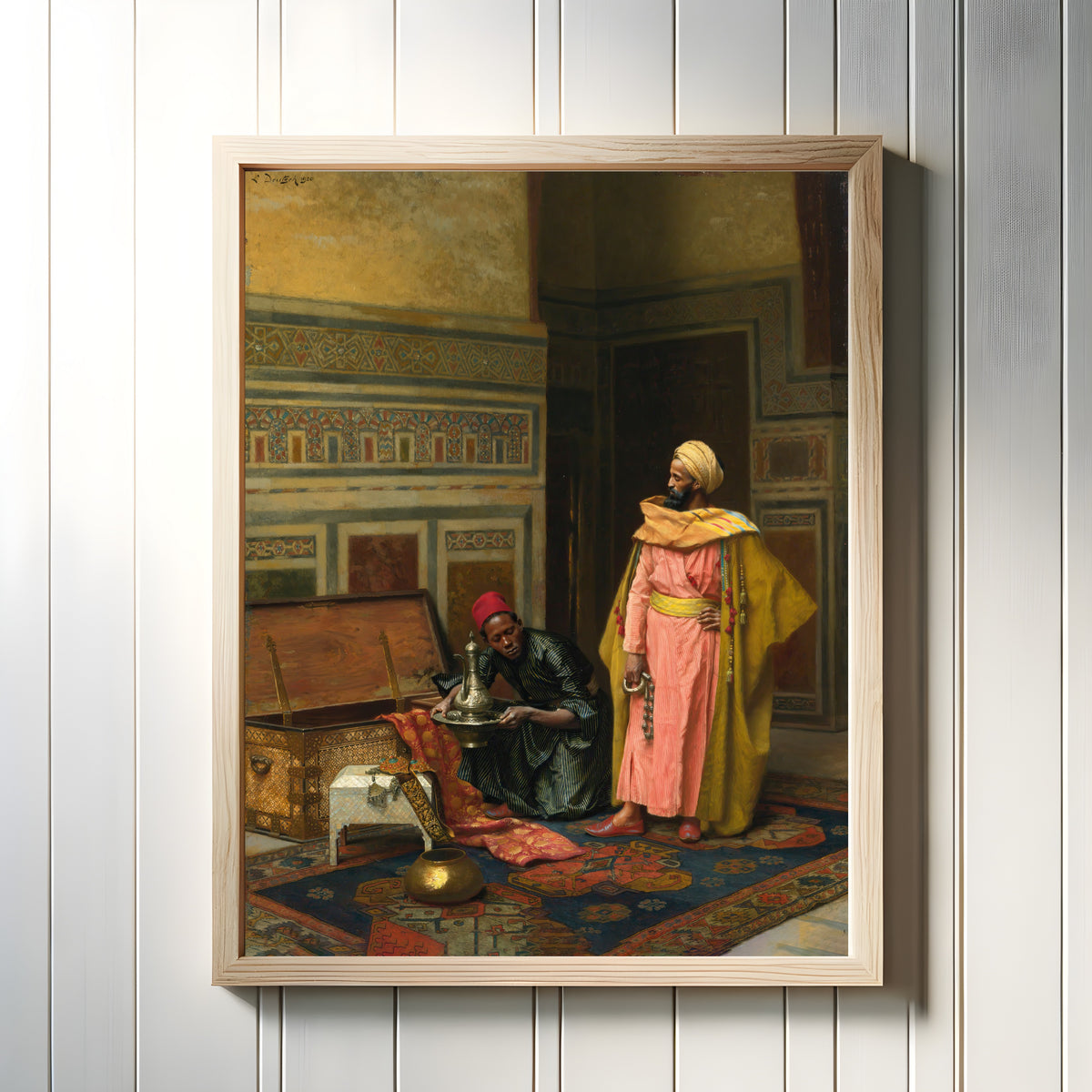 Framed art print of The Treasure Chest by Ludwig Deutsch, in a light wood frame on a white panelled wall