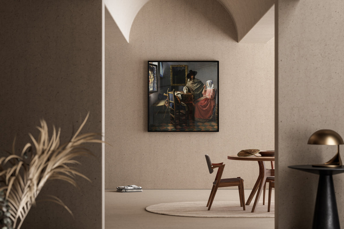 Framed art print of The Wine Glass by Johannes Vermeer, in a sunlit dining corner