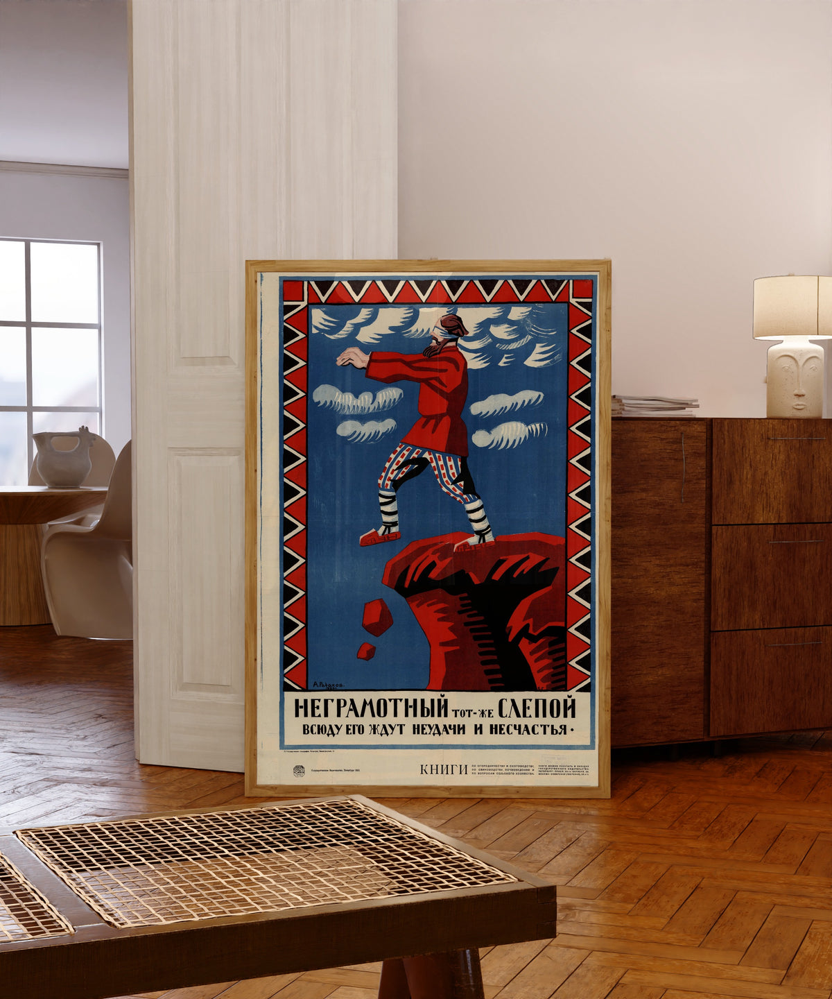Framed art print of The illiterate is as good as blind: failure and… by Aleksei Radakov, in a light wood frame leaning in a warm room with a parquet floor