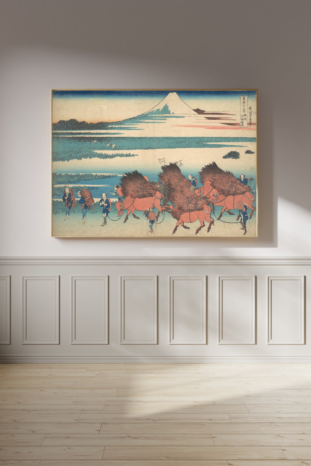 Framed art print of Thirty-six Views of Mount Fuji: The New Fields at Ōno in Suruga Province by Katsushika Hokusai, on a panelled wall in afternoon light