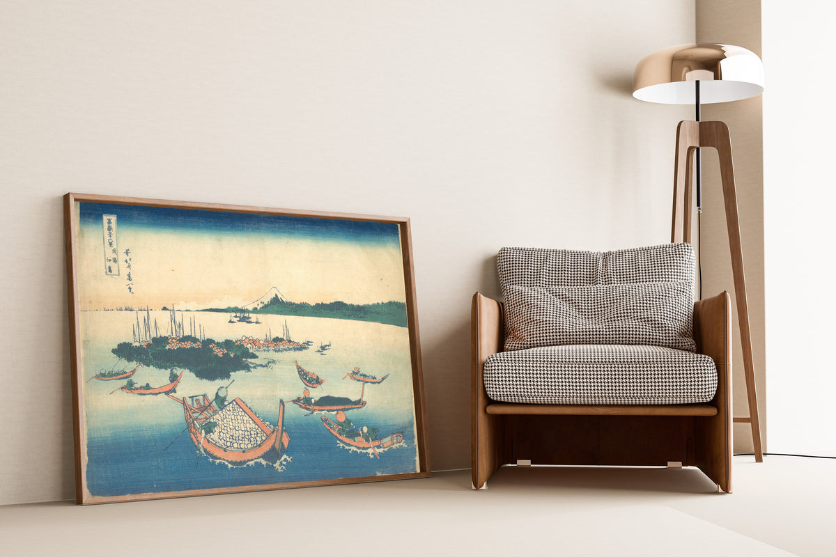 Framed art print of Thirty-six Views of Mount Fuji: Tsukudajima in Musashi… by Katsushika Hokusai, leaning against a wall beside an armchair and a floor lamp