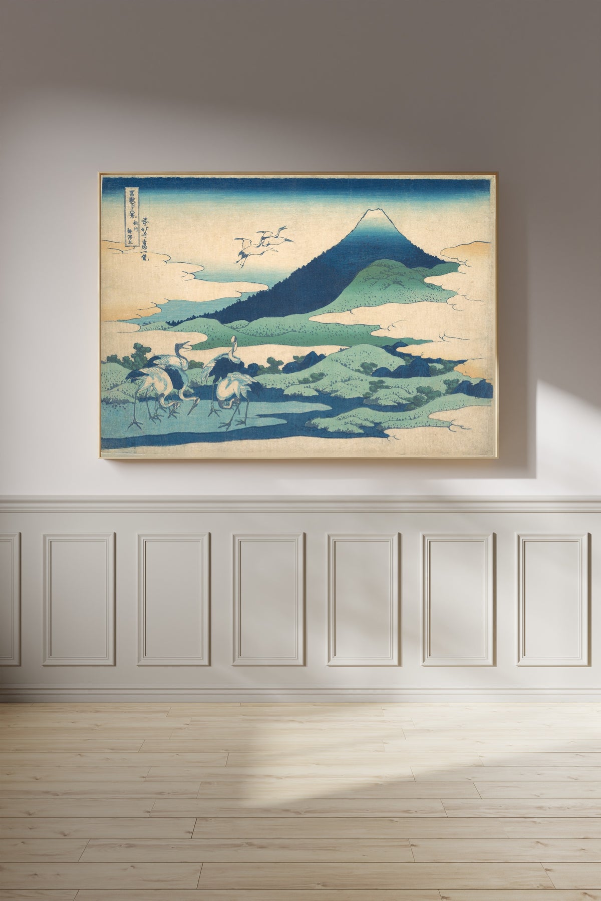 Framed art print of Thirty-six Views of Mount Fuji: Umezawa Manor in Sagami Province by Katsushika Hokusai, on a panelled wall in afternoon light