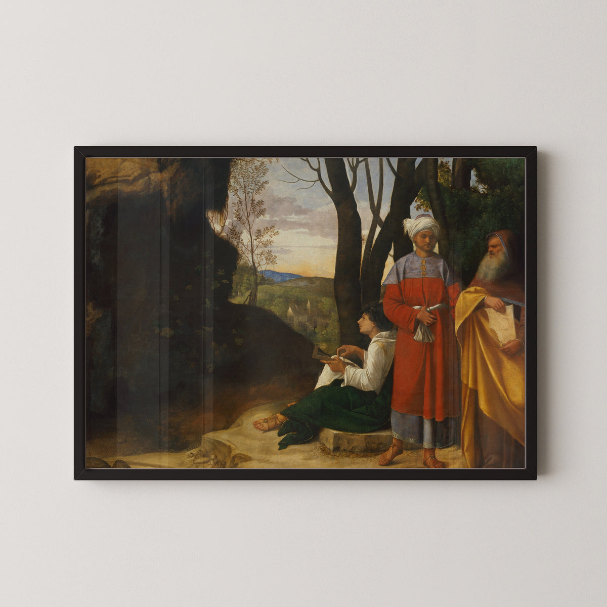 Framed art print of Three Philosophers by Giorgione, in a black frame on a pale wall