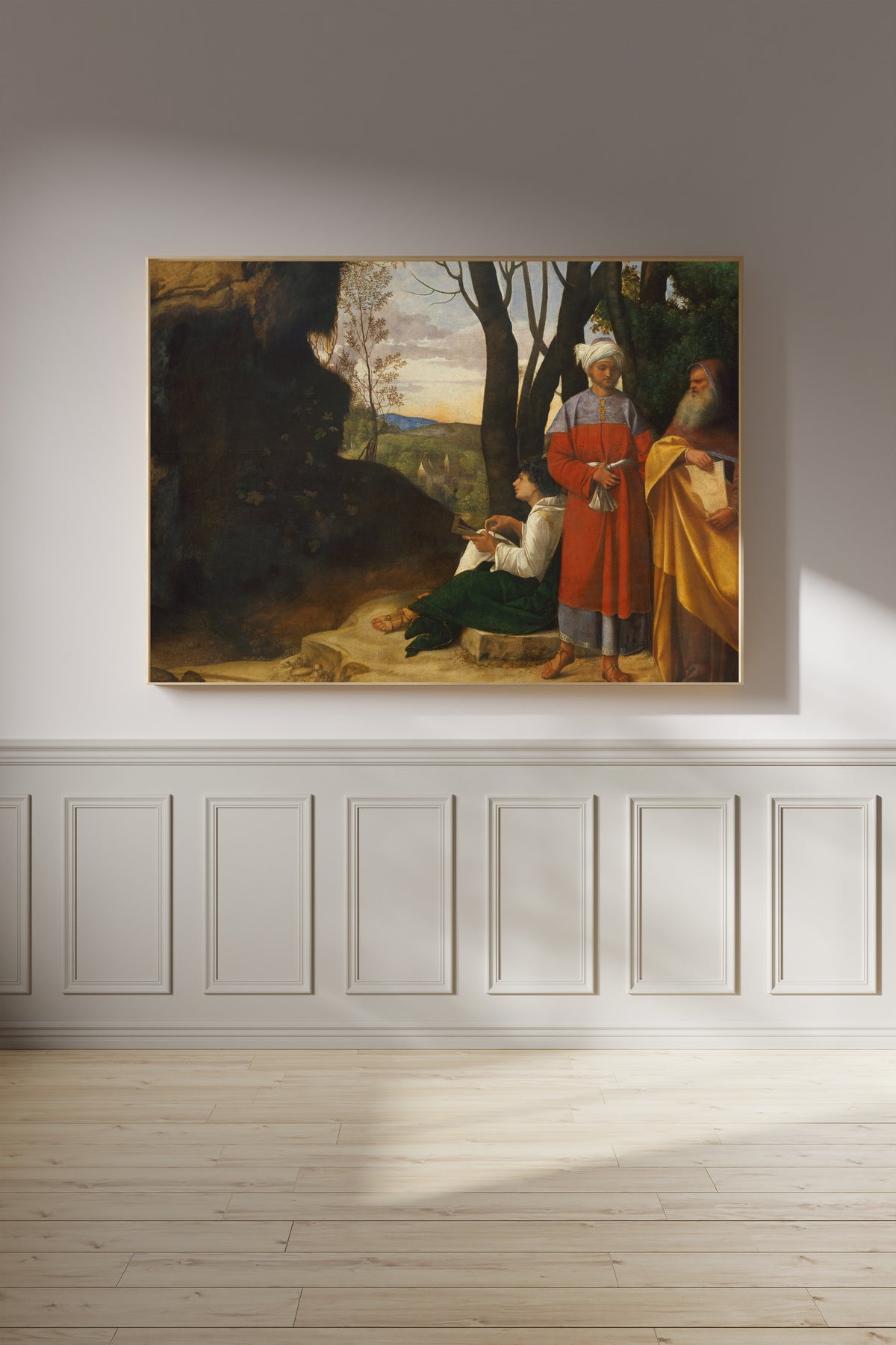 Framed art print of Three Philosophers by Giorgione, on a panelled wall in afternoon light