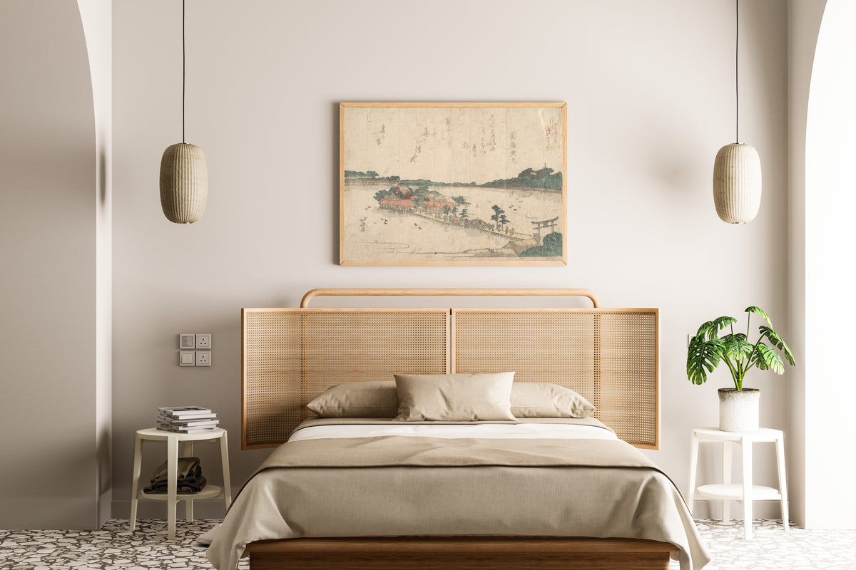 Framed art print of Three Shrines of the Goddess Benten: Shinobazu Pond in Ueno by Katsushika Hokusai, above a cane-headboard bed