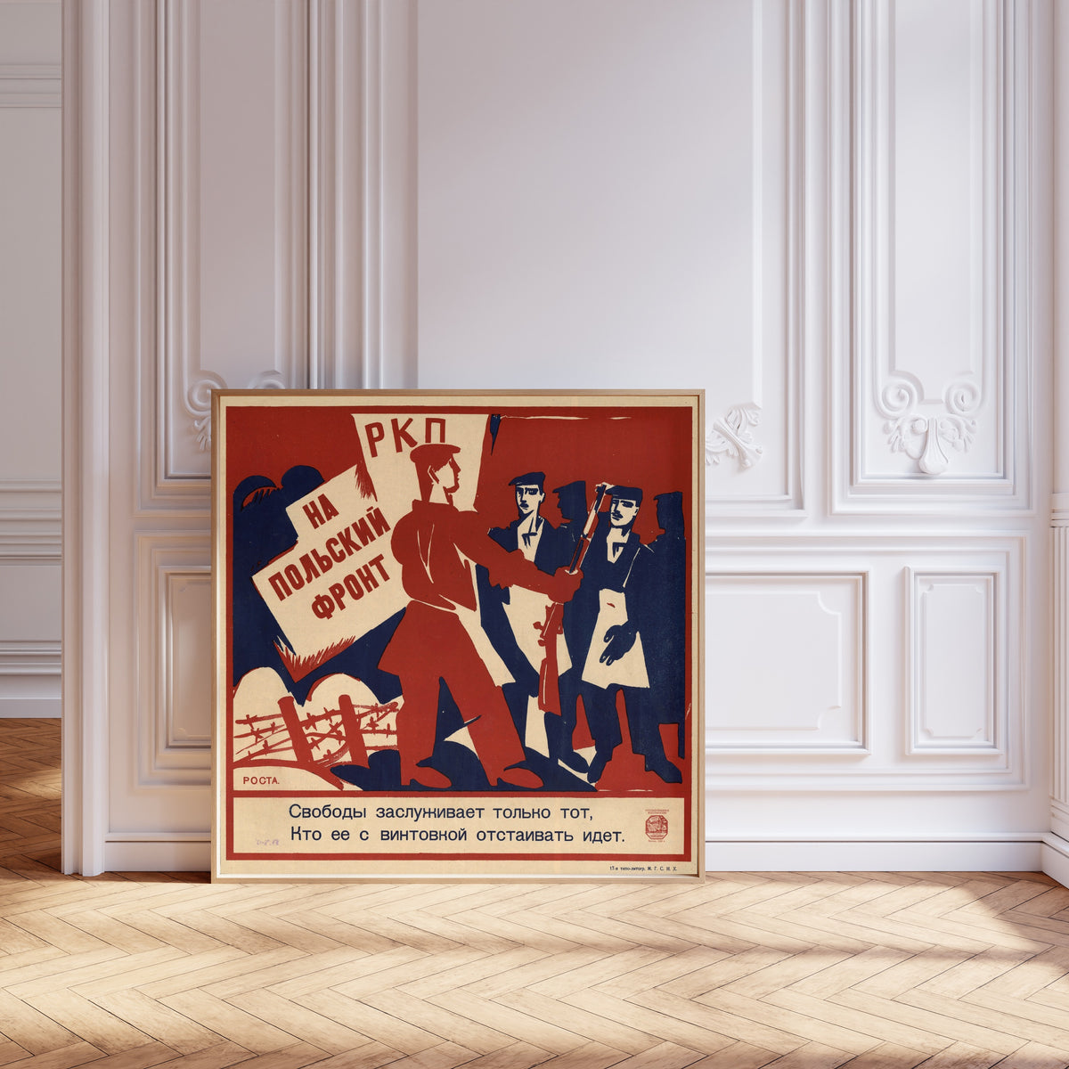 Framed art print of To the Polish front: only he deserves freedom who goes to… by Ivan Malyutin, leaning against pale pink panelling on a herringbone floor