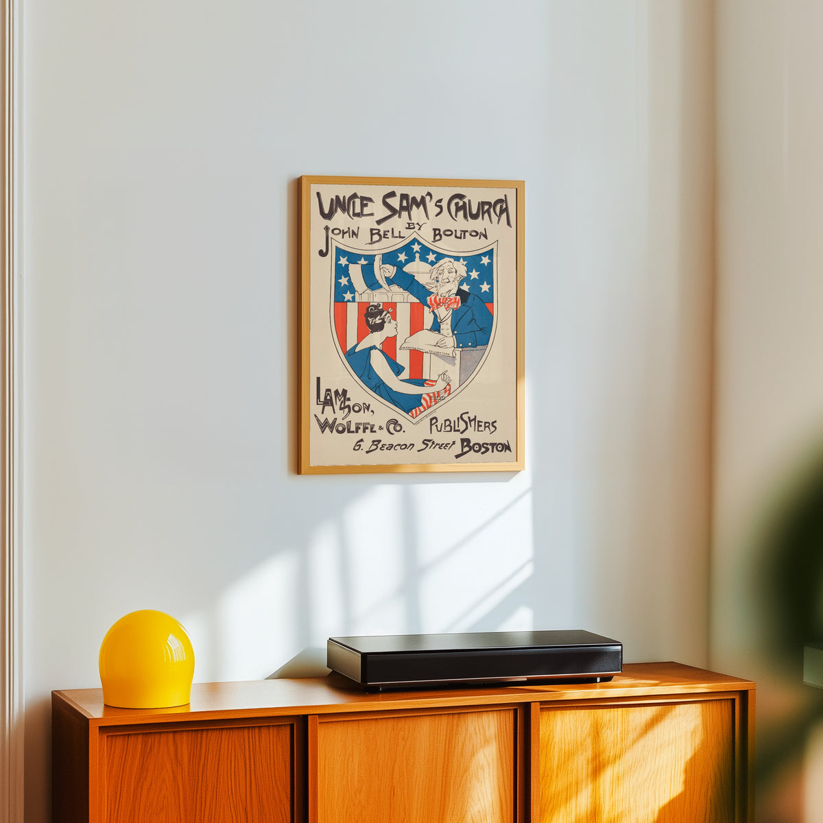 Framed art print of Uncle Sam's Church by Ethel Reed, in a light wood frame on a white wall above an orange sideboard