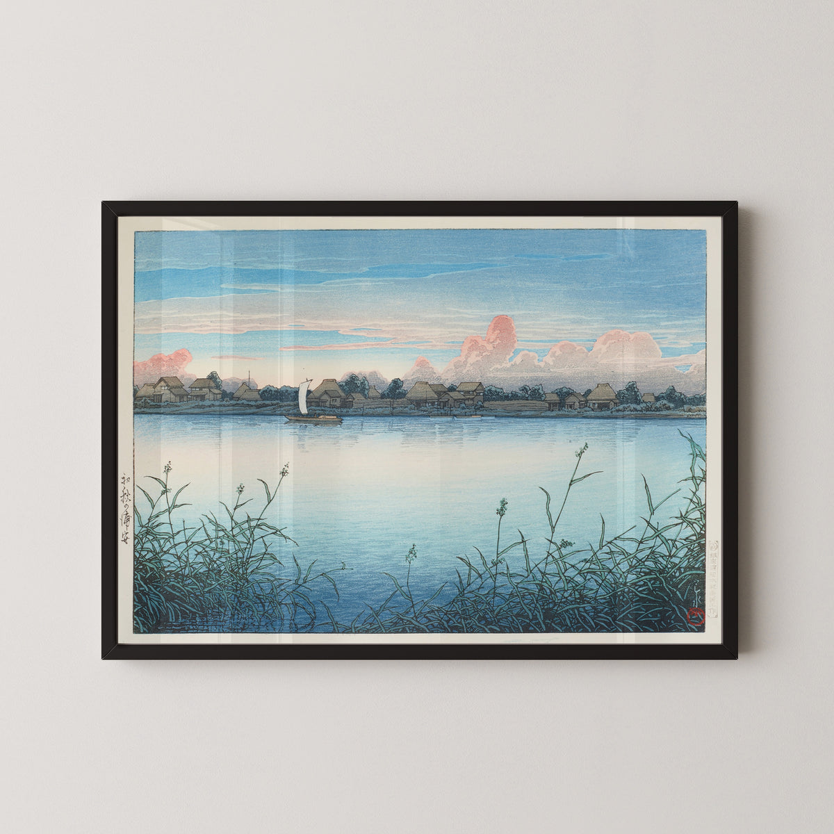 Framed art print of Urayasu in Early Autumn by Kawase Hasui, in a black frame on a pale wall