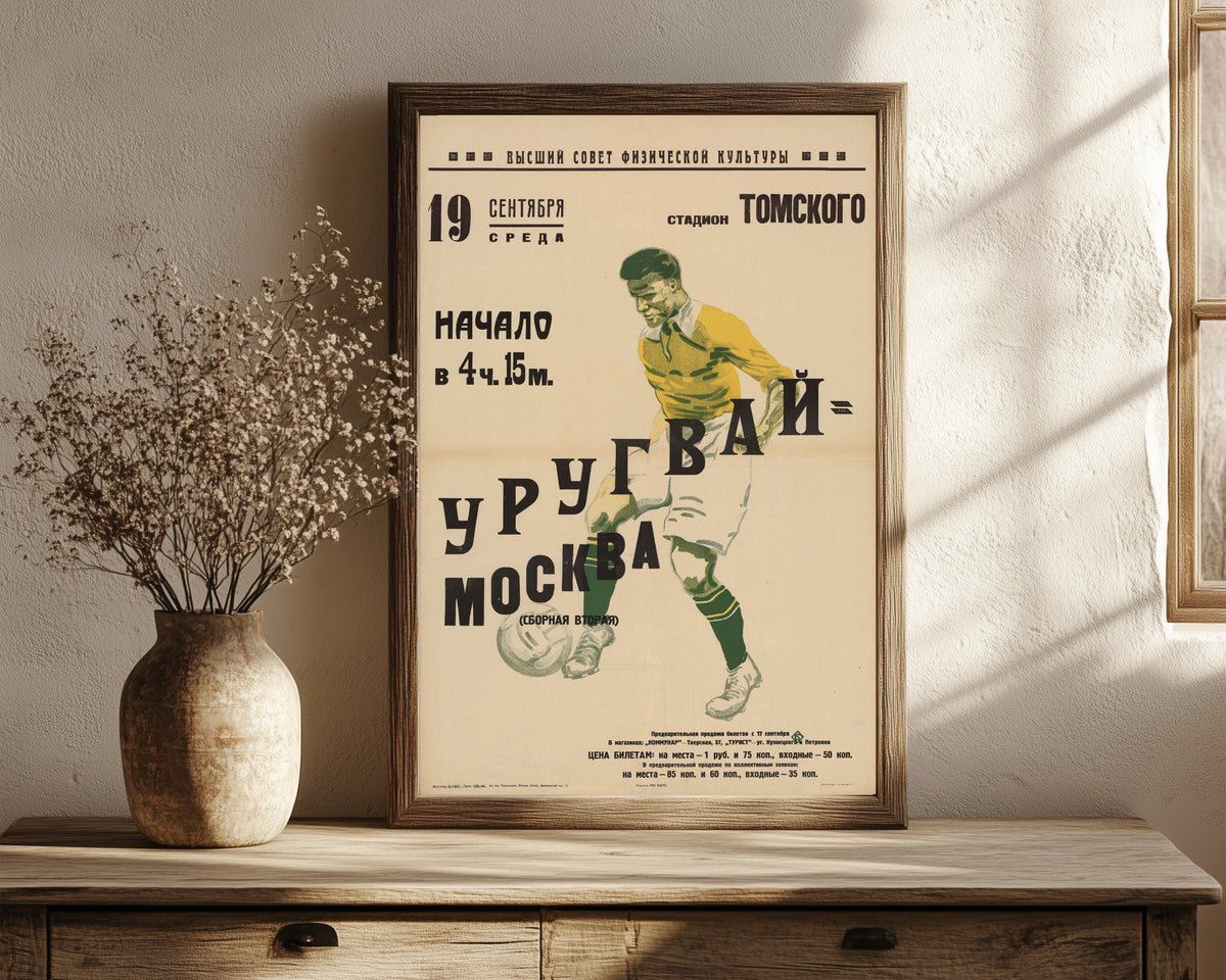 Framed art print of Moscow (second team), in a dark wood frame leaning on a rustic console beside dried flowers