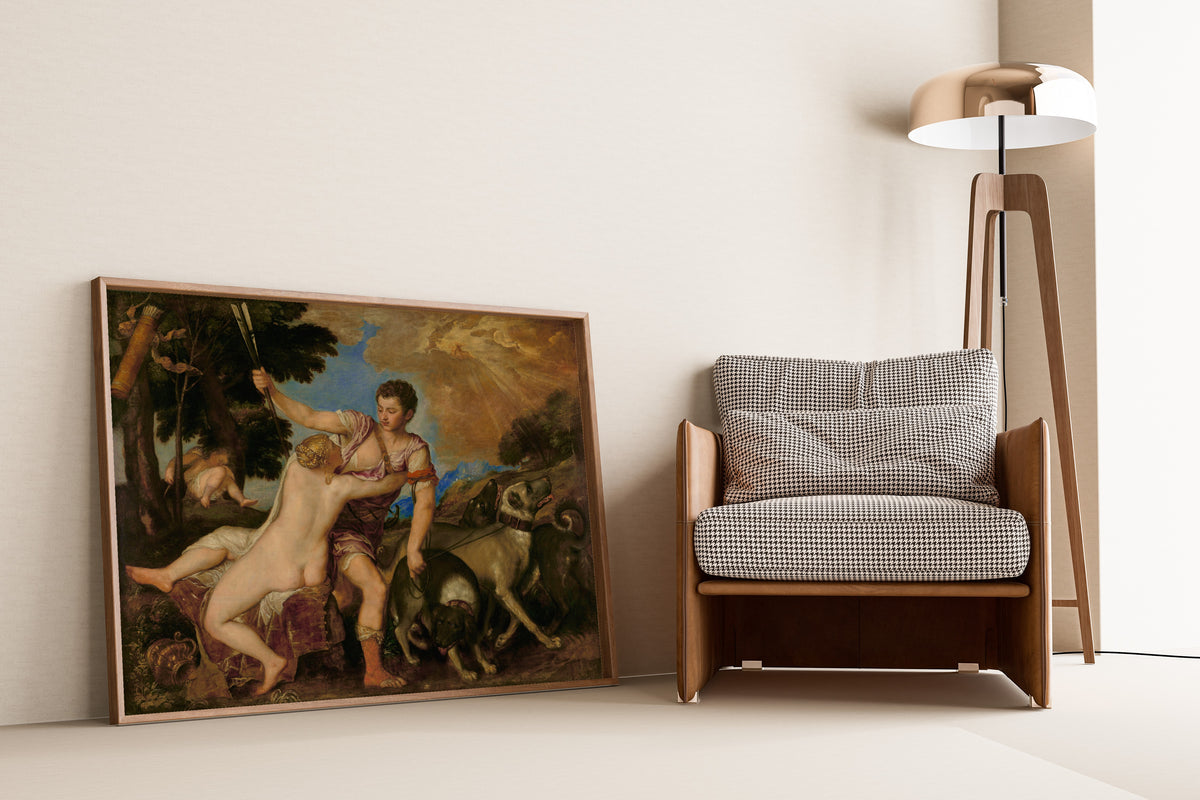 Framed art print of Venus and Adonis by Titian, leaning against a wall beside an armchair and a floor lamp