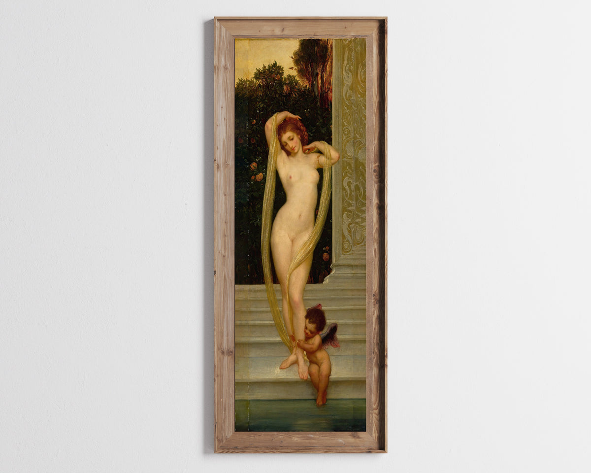 Framed art print of Venus and Cupid by Frederic Leighton, in a tall wooden frame on a pale wall