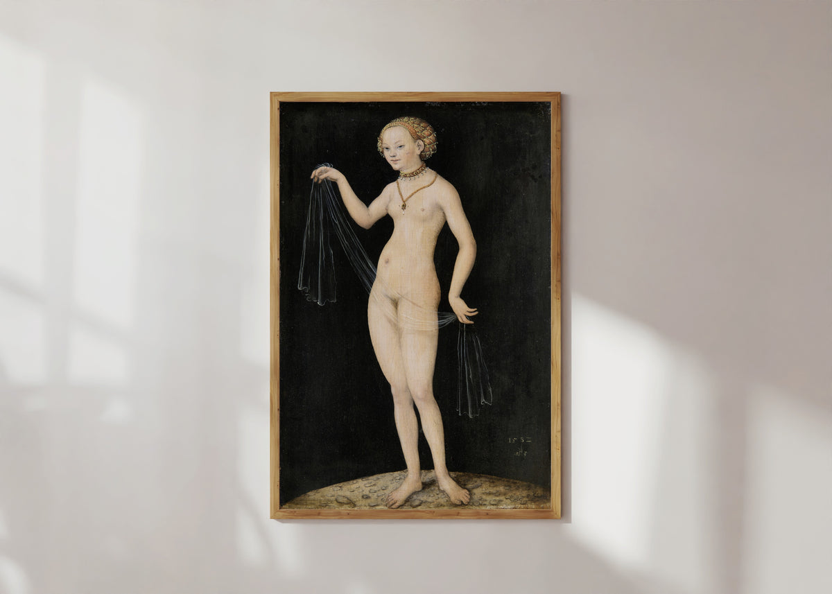 Framed art print of Venus by Lucas Cranach the Elder, in a light wood frame on a sunlit white wall