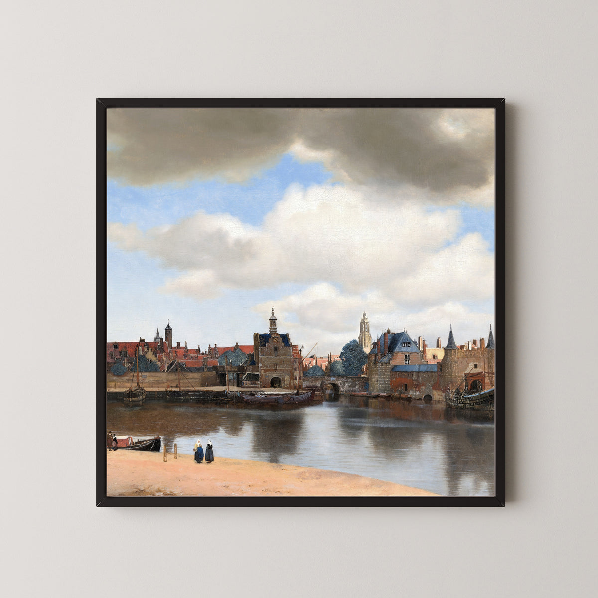 Framed art print of View of Delft by Johannes Vermeer, in a black frame on a pale wall