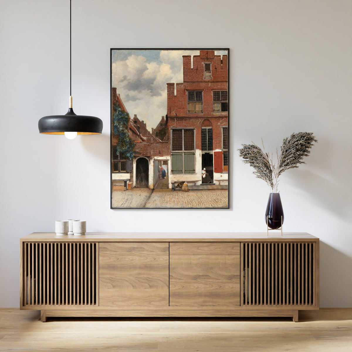 Framed art print of View of Houses in Delft, Known as ‘The Little Street’ by Johannes Vermeer, above a slatted wood sideboard